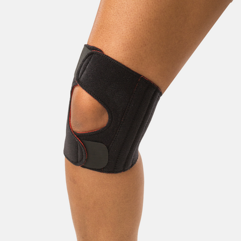 Black Thermoskin Sports Adjustable Knee Stabiliser worn on a knee, with open patella and adjustable straps